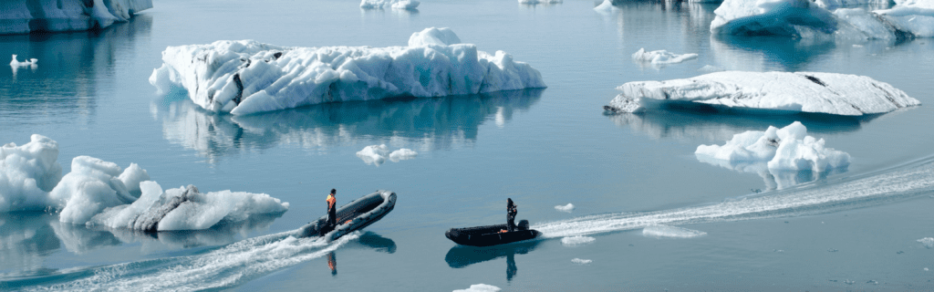 Two boaters pass by in Jökulsárlón, Iceland. (Photo by Rolf Gelpke via Unsplash)