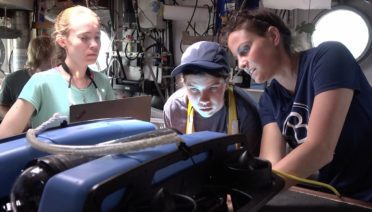 WHOI mechanical engineer Molly Curran troubleshoots Blue ROV with Massachusetts high school students during a 2023 robotics course on the Sea Education Association (SEA) sailboat Corwith Cramer. (Video still by Elise Hugus © Woods Hole Oceanographic Institution)