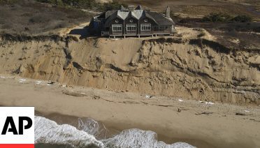 A home sits atop of a sandy bluff overlooking a beach in Wellfleet, Mass., Monday, Jan. 27, 2025. (AP Photo/Andre Muggiati)