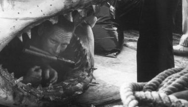 Richard "Dick" Edwards plants dynamite in the mechanical shark prop used in filming the classic movie Jaws. During his service in the U.S. Navy during World War II and the Korean War, Edwards became an expert in explosives. Early in his early career at WHOI, he applied his knowledge of explosives to the work of seismic researchers, though Navy officials continued to call on his expertise for many years. (Cliff Winget/©Woods Hole Oceanographic Institution)
