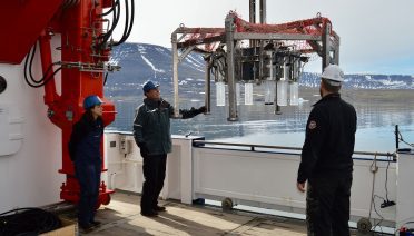 Don Anderson (center) and WHOI-MIT Joint Program student Alexis Fischer help to deploy a multi-corer to search for Alexandrium catenella cysts in Arctic sediments. (Photo courtesy of Don Anderson, © Woods Hole Oceanographic Institution)
