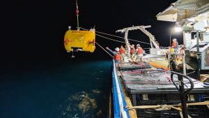 Bosun Oscar Sisson (left) and WHOI engineers Sean Kelley, Mike Skowronski, and Isaac Vandor deploy the autonomous underwater vehicle Sentry 