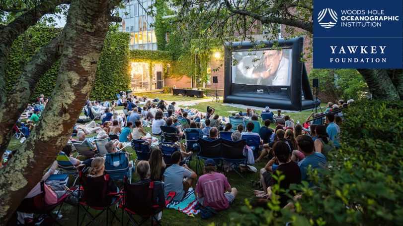 Audience watches an outdoor film screening at WHOI's Ocean and Climate Outreach Series event.