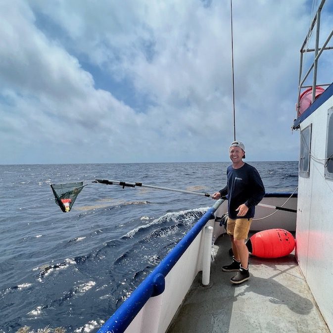 Braun retrieves a tag that had popped off a fish. Fish can travel for miles before the tag pops off, making retrieval by boat a time-consuming process. (Photo by Martin Arostegui, © Woods Hole Oceanographic Institution)